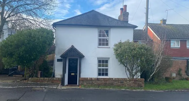 A white house sitting on the side of a road.