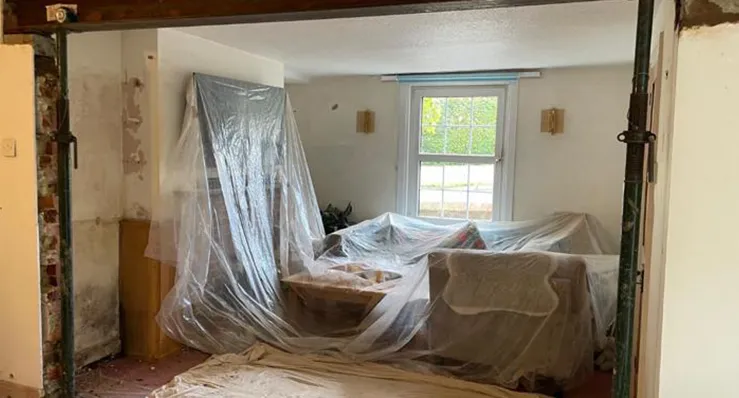 A room that is being remodeled with plastic covering the walls.