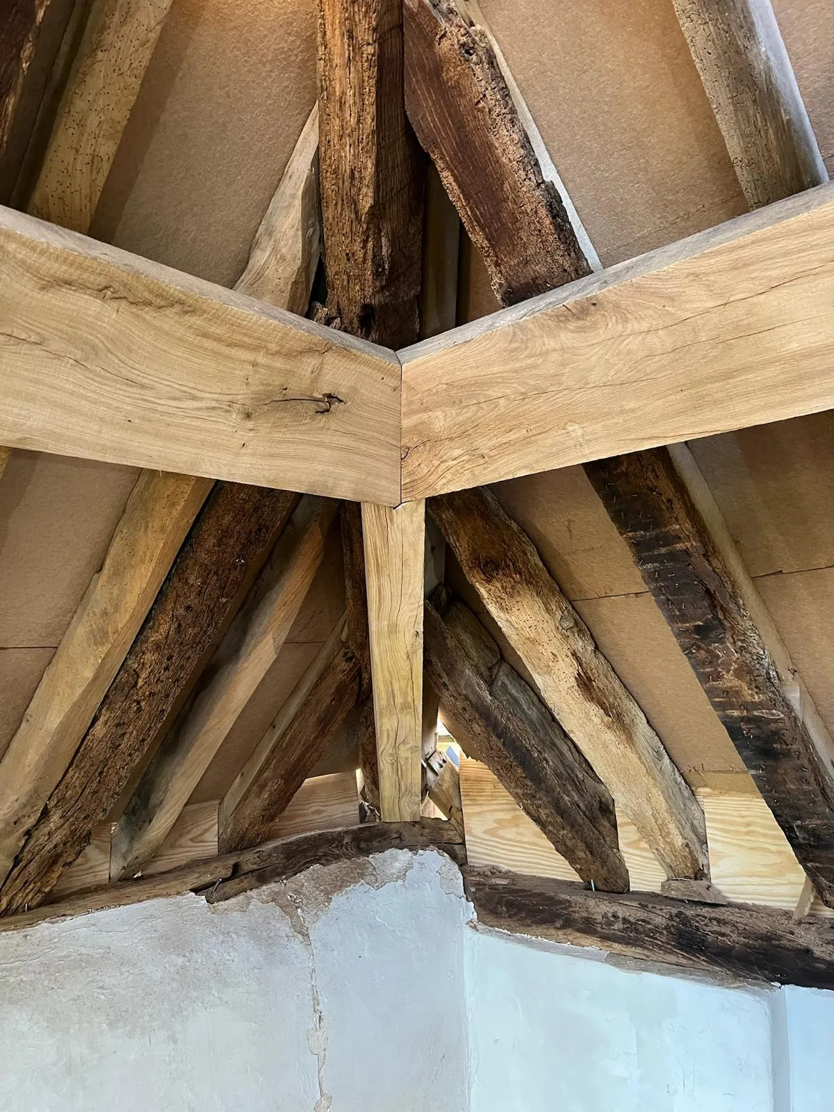 A wooden ceiling with exposed beams and a light fixture.