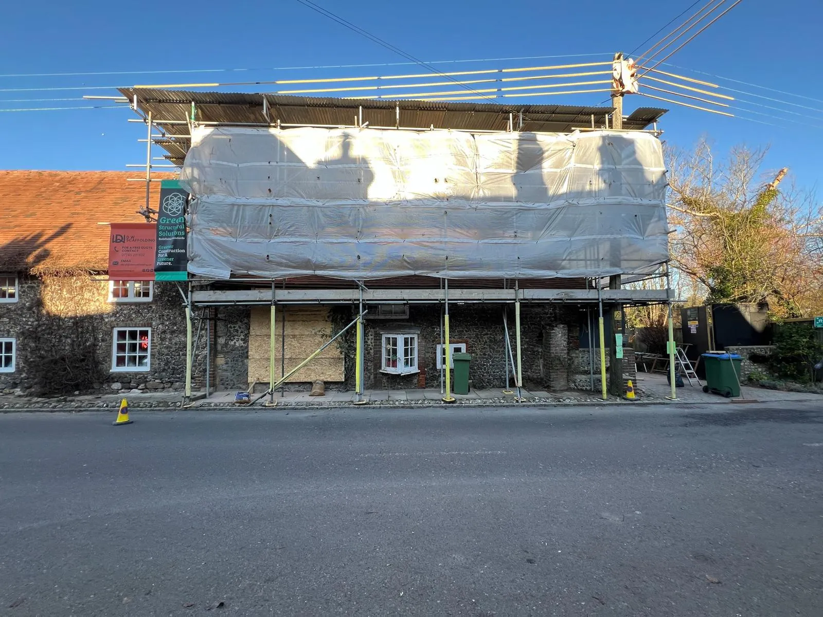 A building under construction with a tarp covering it.
