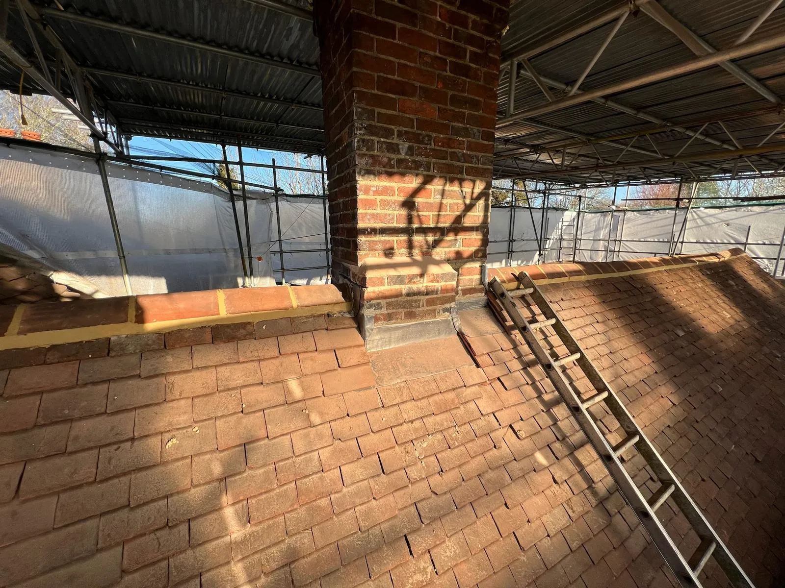 A brick building with a metal ladder next to it.