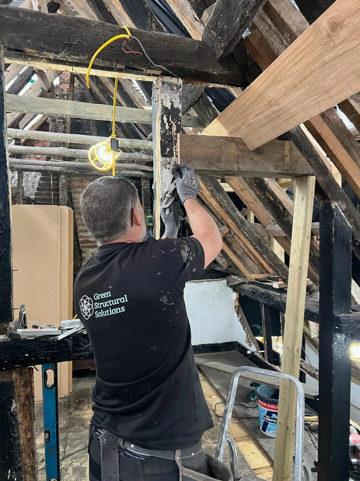 A man working on a ceiling in a building.
