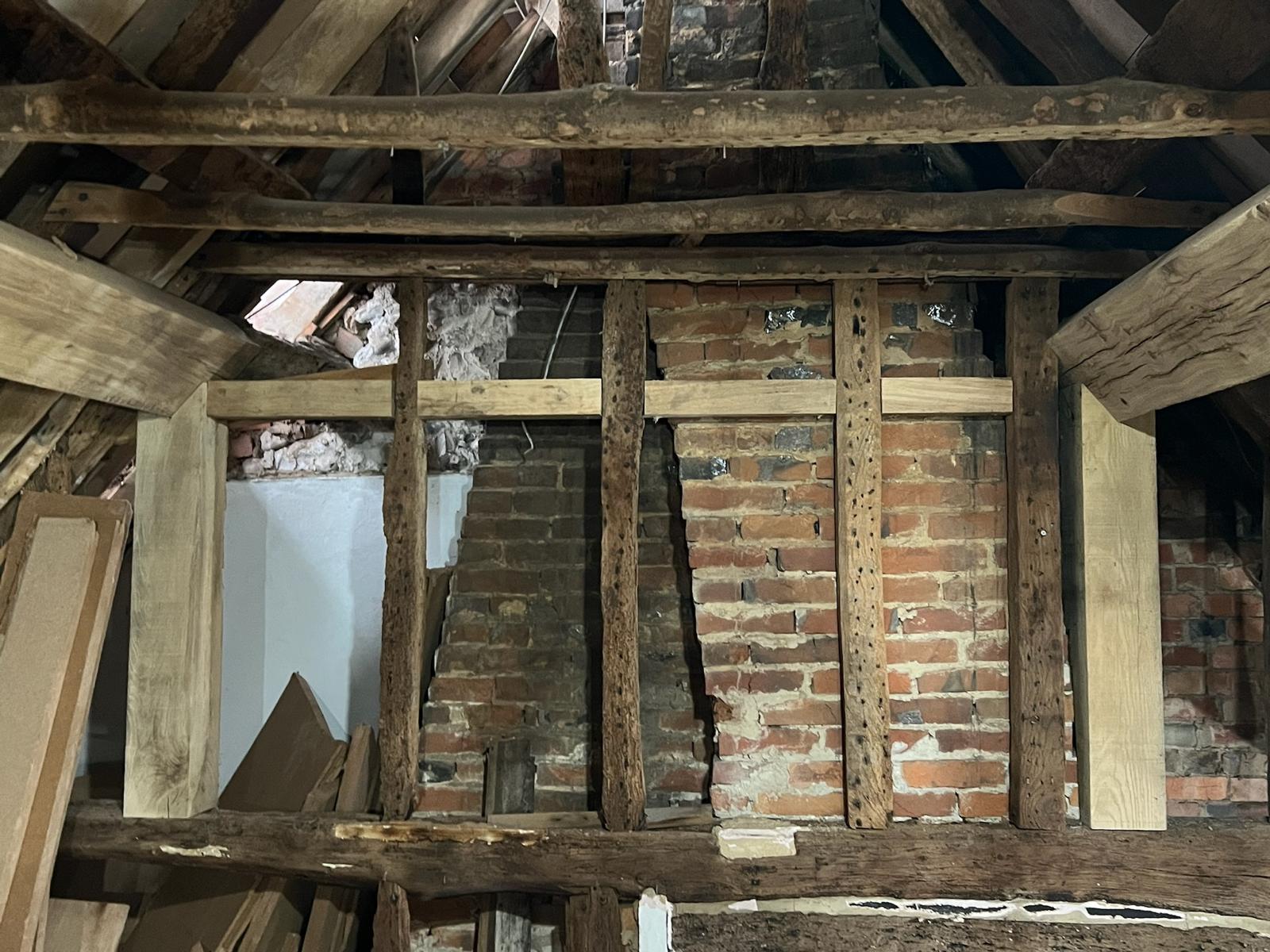 A room with exposed wood and brick walls.